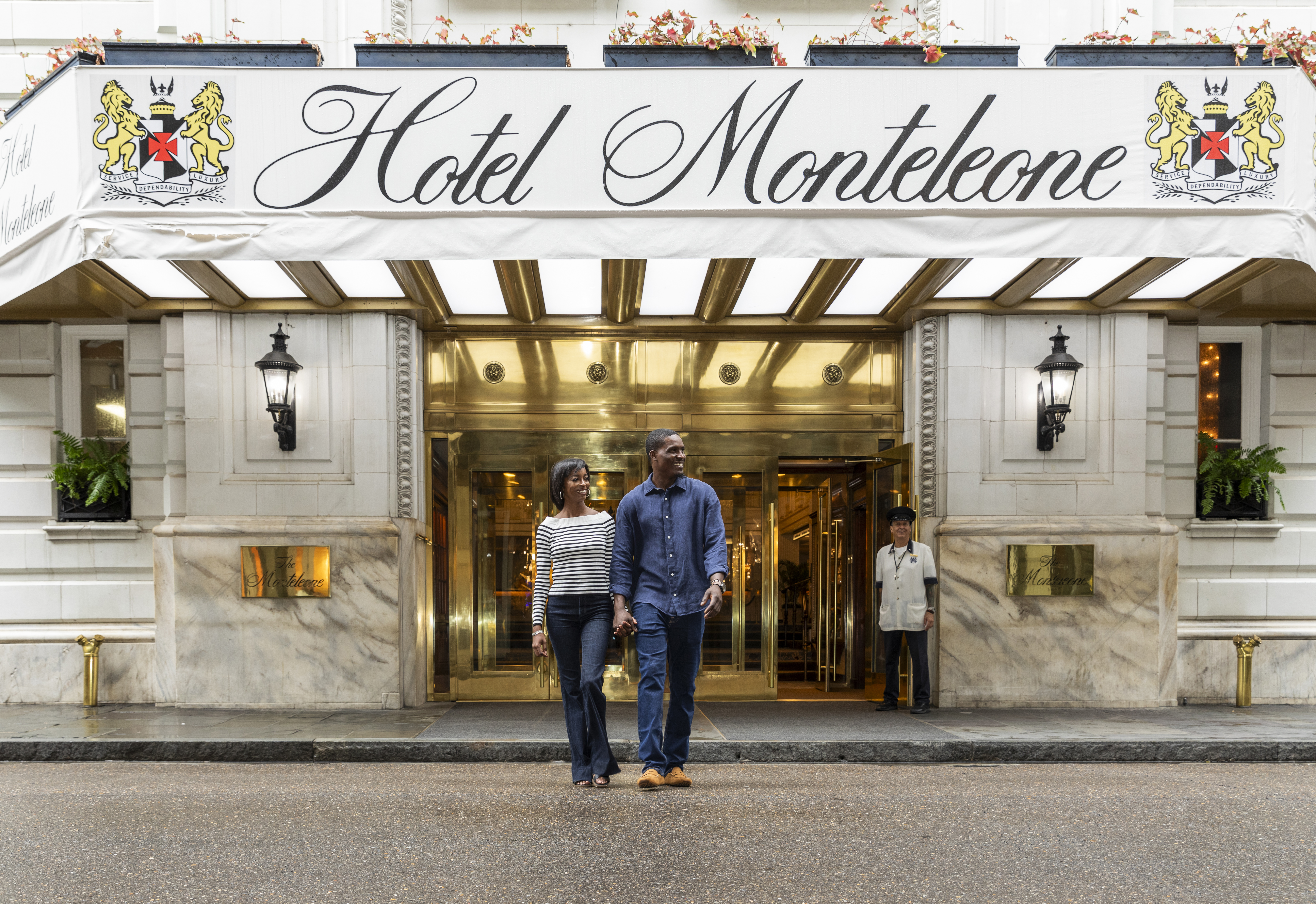 A couple walks in front of the Hotel Monteleone entrance