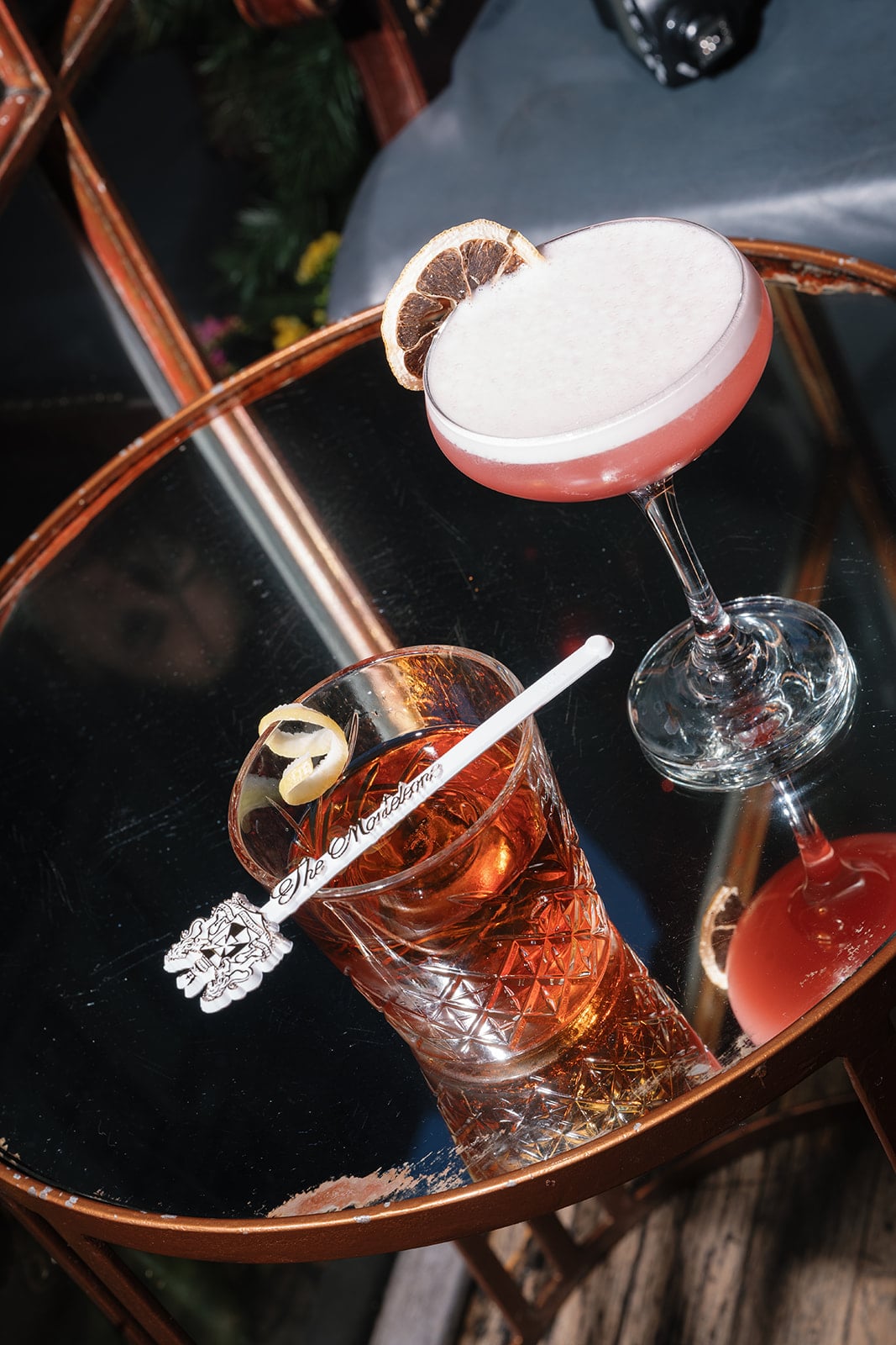 Signature Monteleone cocktails: pink foam with dried orange and amber drink with lemon peel.