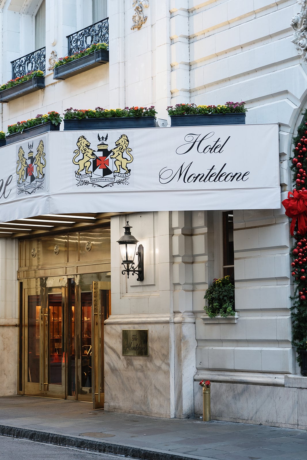Grand facade and entrance of Hotel Monteleone in New Orleans, featuring its ornate sign and golden revolving doors.
