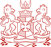 Red heraldic crest with two lions, shield, crown, and fleur-de-lis, symbolizing New Orleans' French heritage.