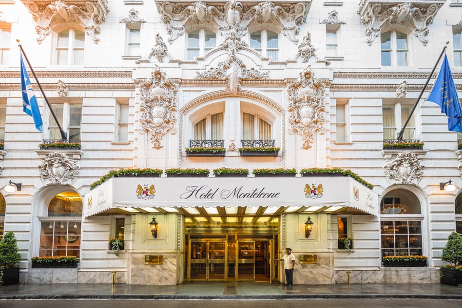 Grand entrance of Hotel Monteleone in New Orleans, an ornate white building with a doorman.