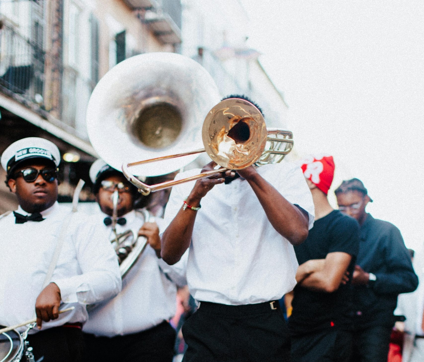 Vibrant New Orleans brass band performing on a street, featuring a trombonist.