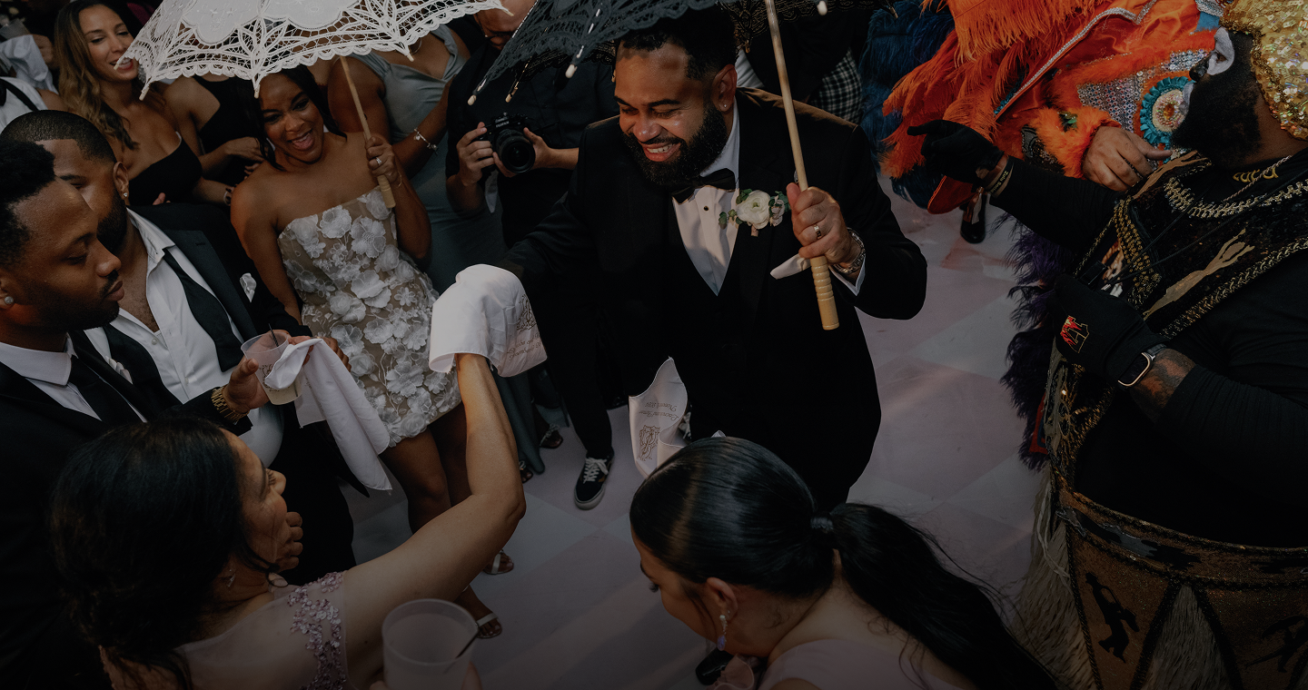 New Orleans Second Line parade with joyful dancers, elegant umbrellas, and a colorful costumed parader.