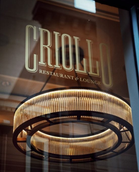 Criollo Restaurant & Lounge entrance in New Orleans with a glowing modern circular chandelier.