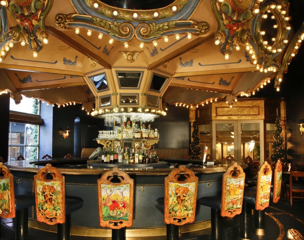 a bar with a carousel-style ceiling and decorative stools