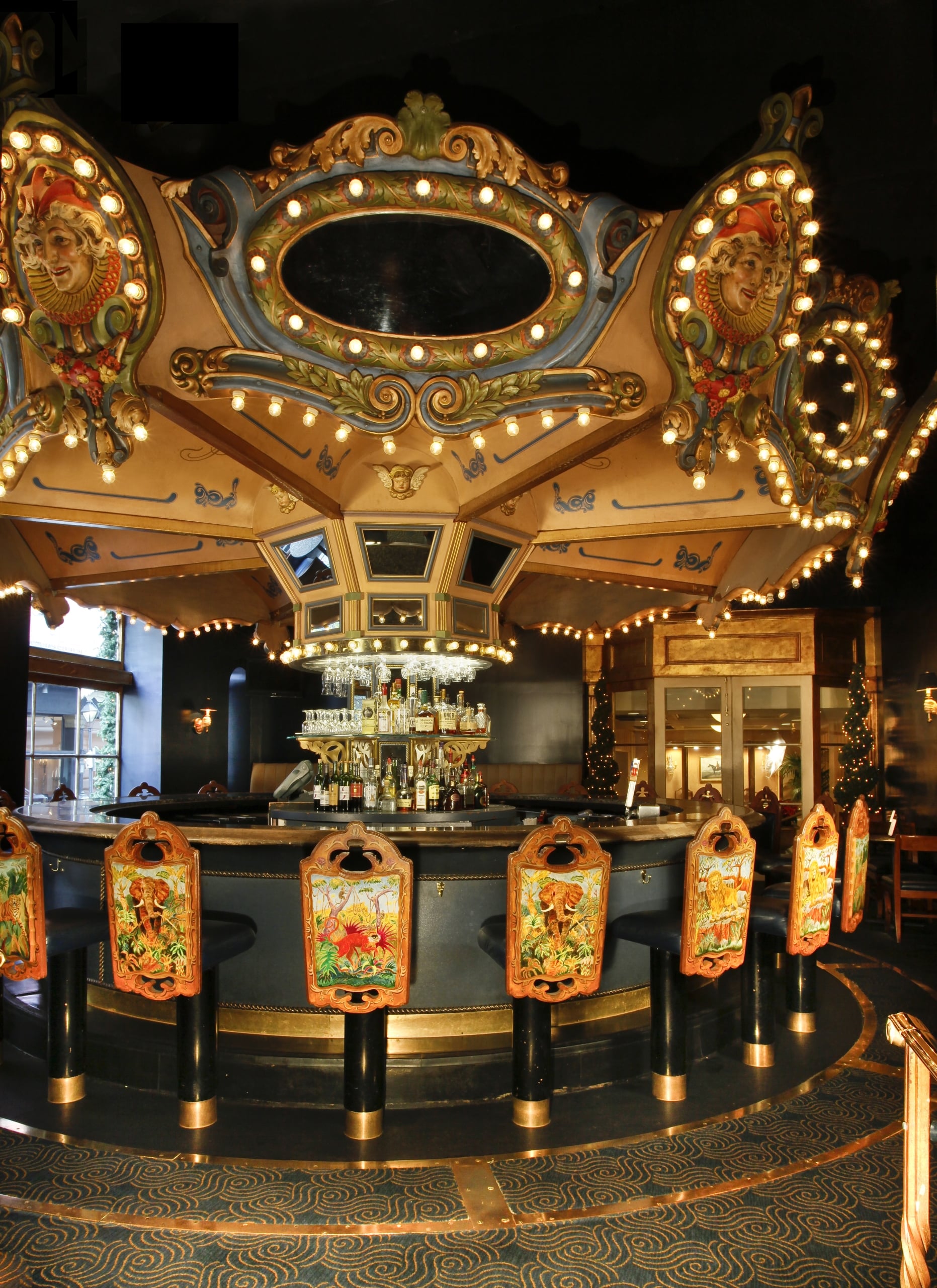Iconic New Orleans carousel bar with ornate carvings, unique animal-painted barstools, and twinkling lights.