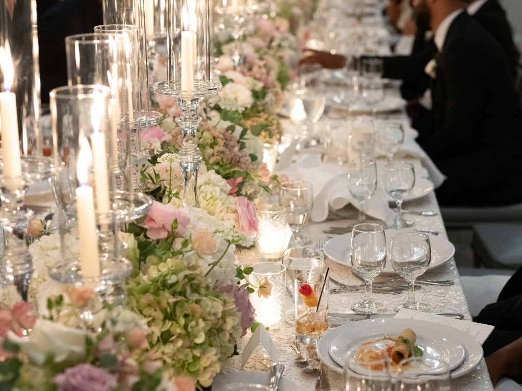 A formal dining table set with candles, flowers, and fine china.