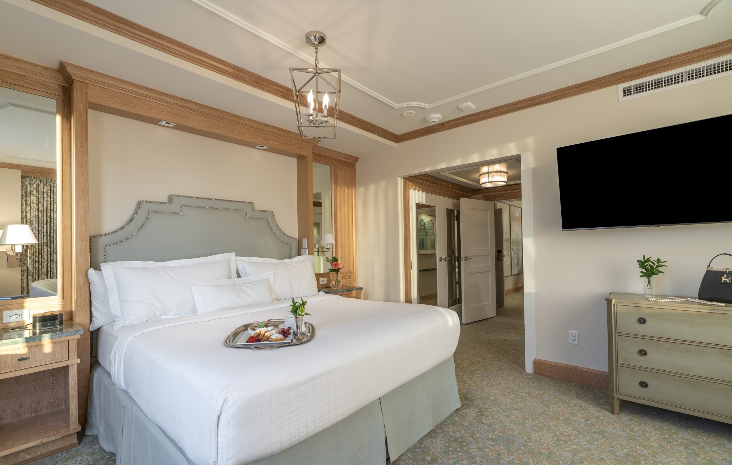 Luxurious New Orleans hotel room with king bed, room service breakfast, and elegant decor.
