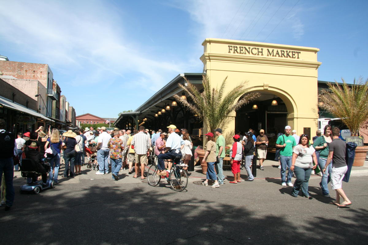 Tourists and locals walk past the historic French Market building in New Orleans.