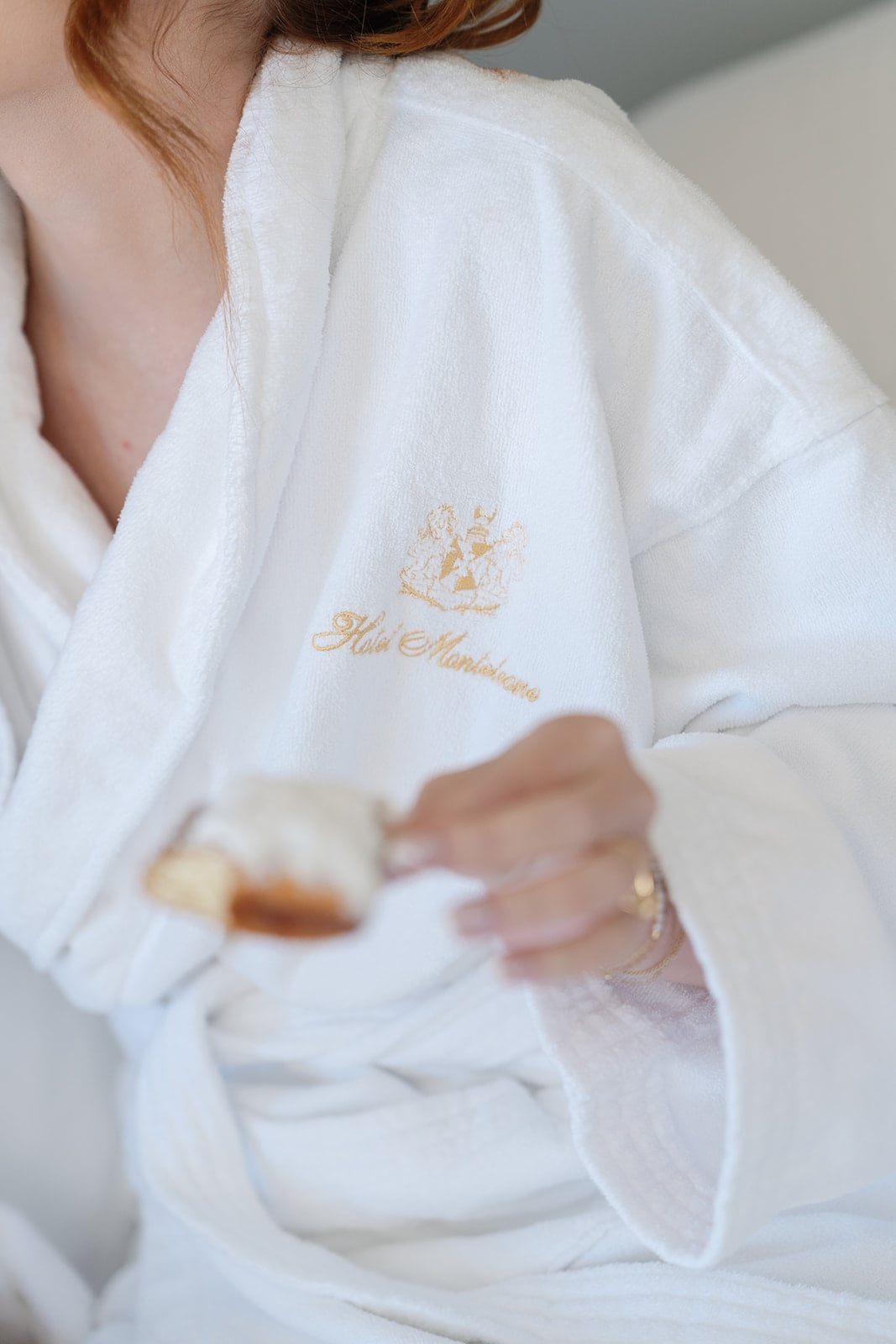 Guest in a Hotel Monteleone bathrobe enjoying a pastry, highlighting luxury New Orleans hospitality.