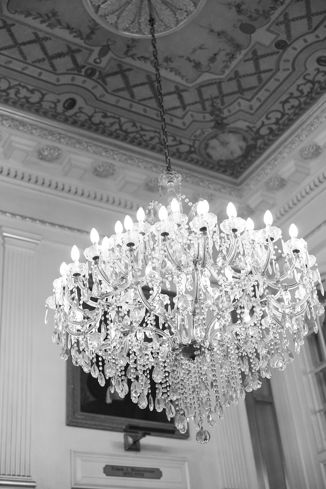 Sparkling crystal chandelier in a grand room with ornate ceiling details, perfect for a New Orleans stay.