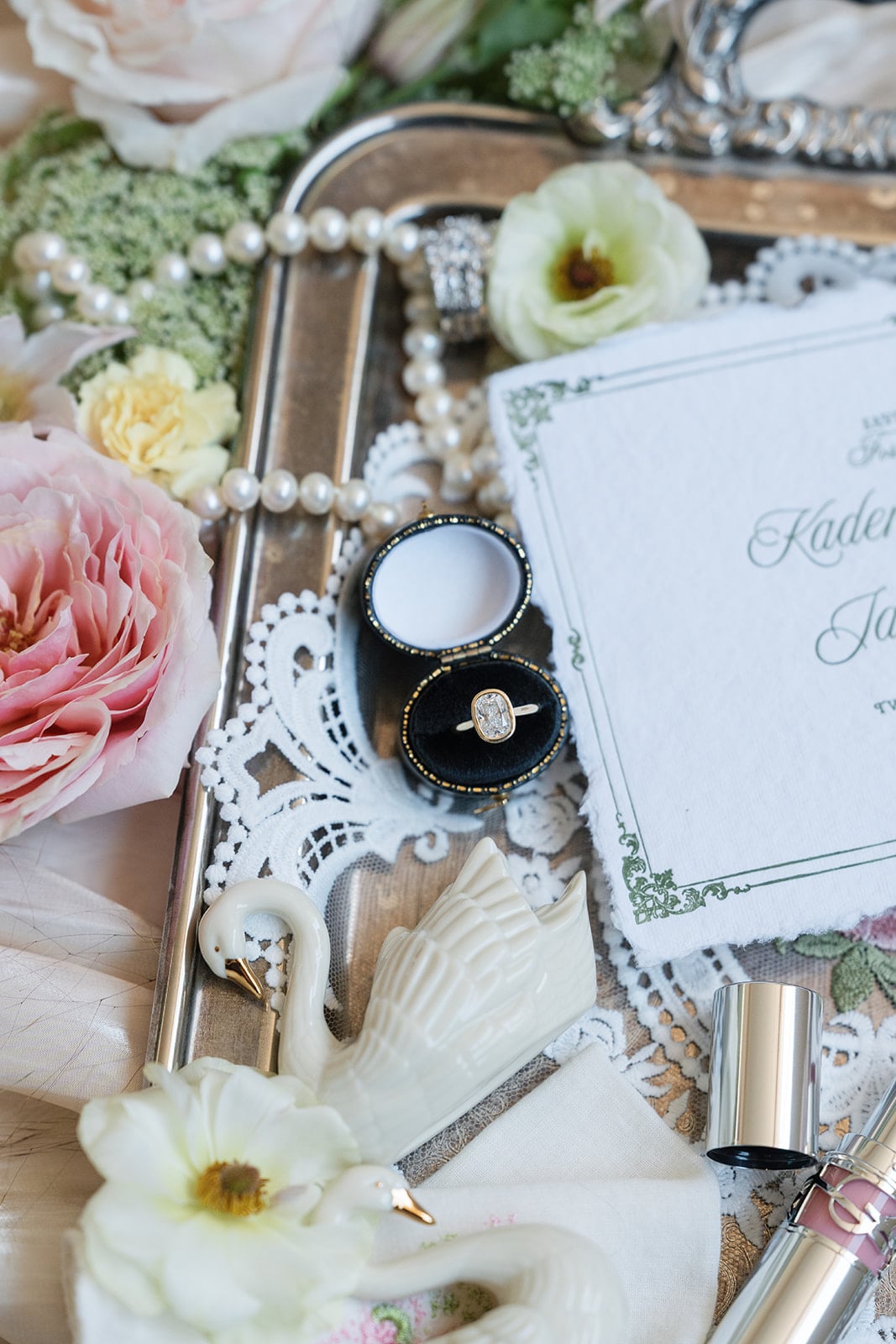 New Orleans luxury wedding details with a diamond engagement ring, invitation, and fresh flowers.