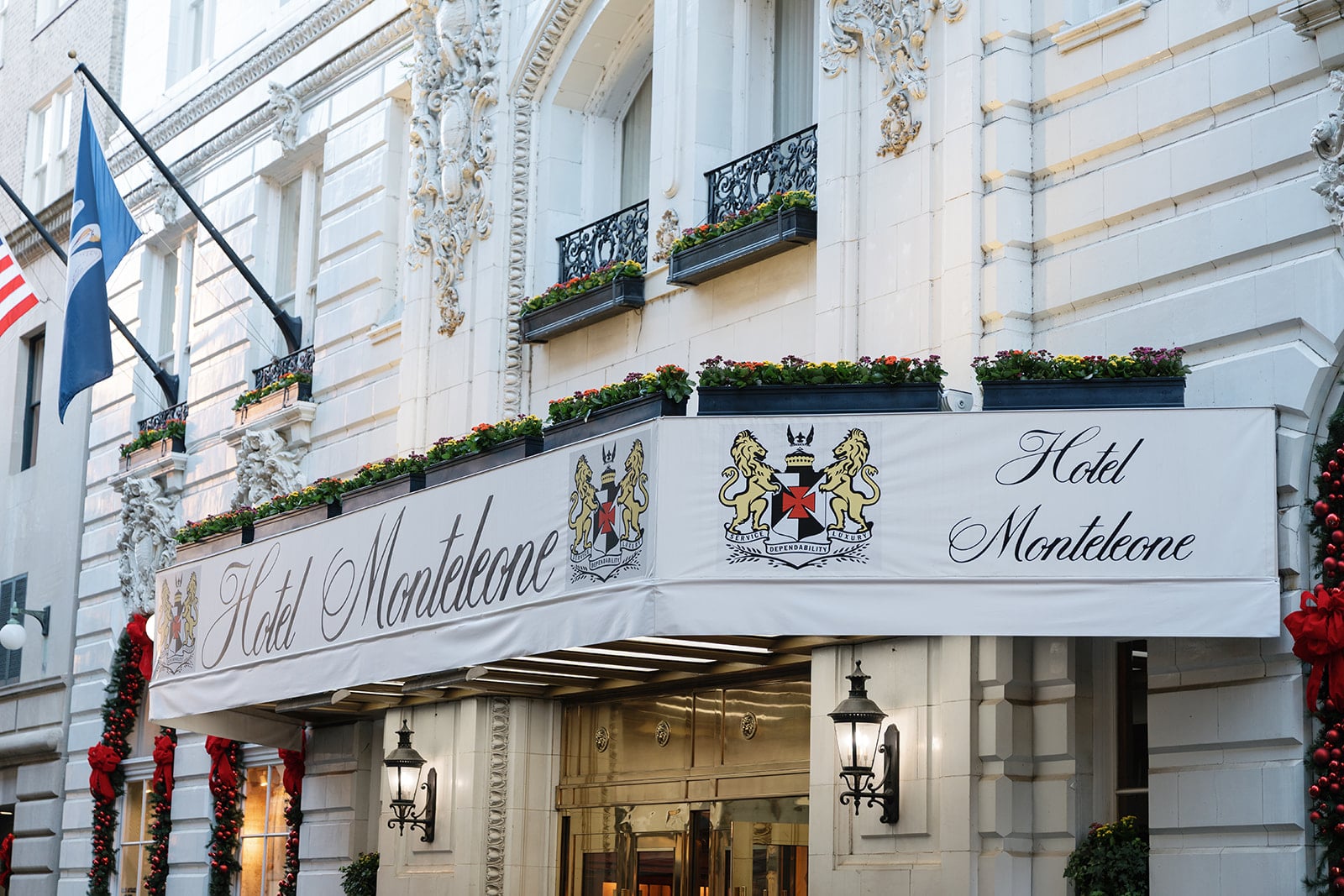 Hotel Monteleone, a historic luxury hotel in New Orleans, with ornate entrance, festive decorations, and state flag.