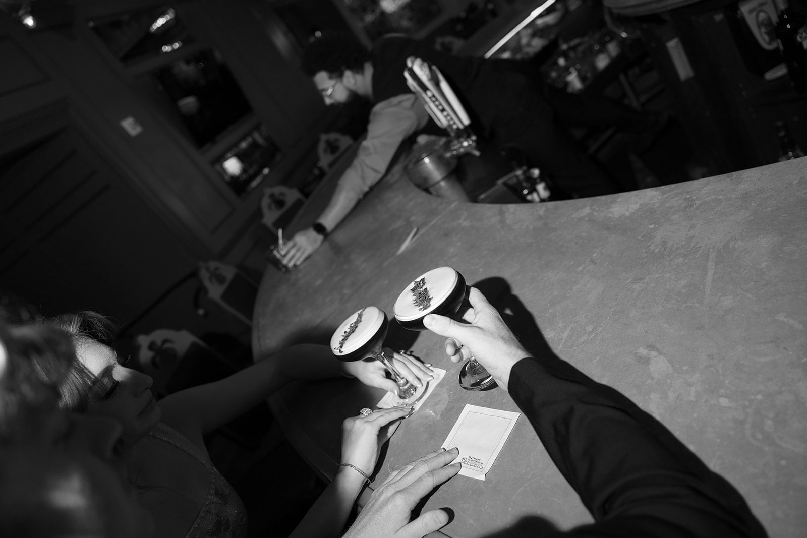 Two people enjoying unique cocktails with artistic foam designs at a vibrant New Orleans bar.