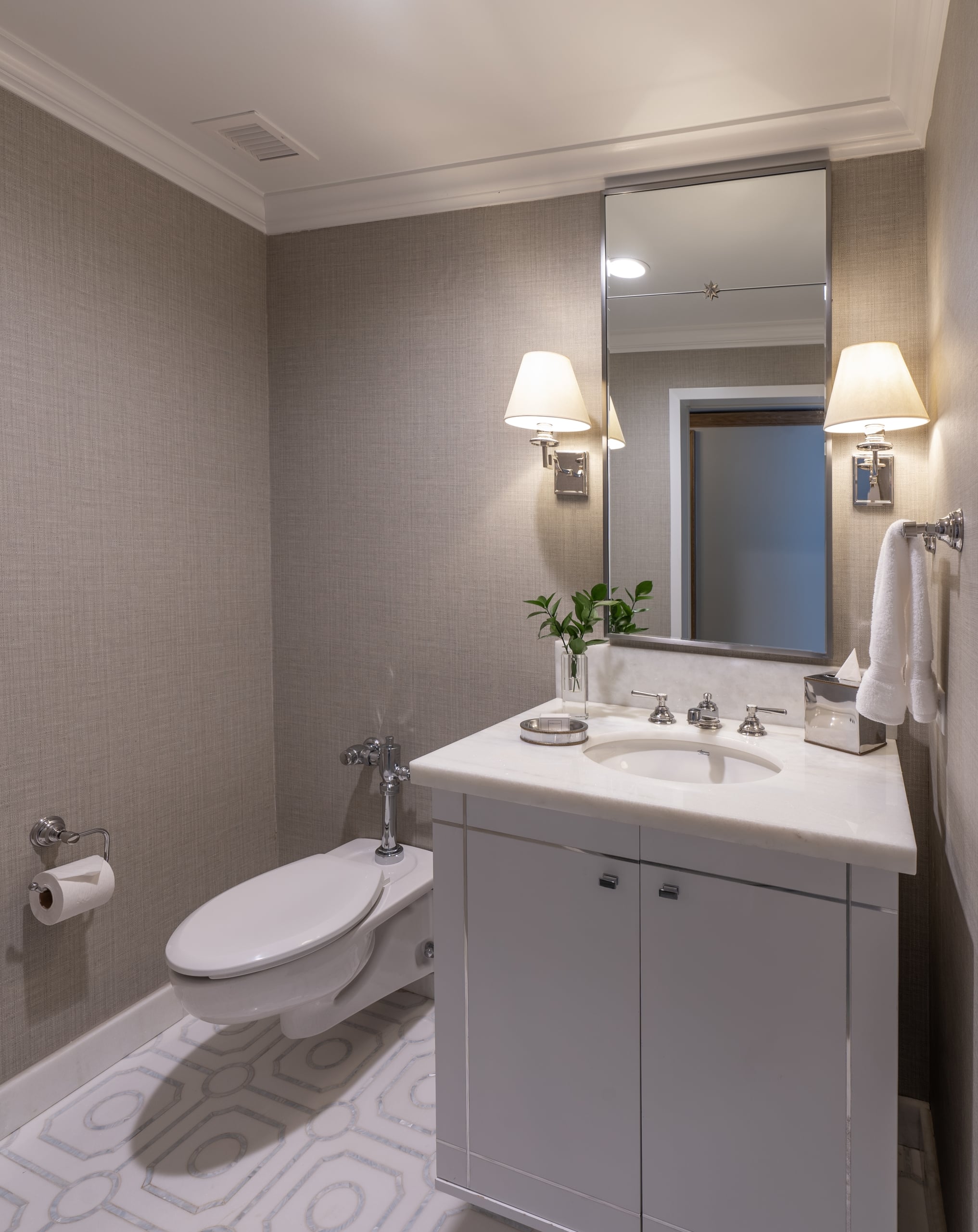Stylish New Orleans bathroom with white marble vanity, modern toilet, and patterned floor.