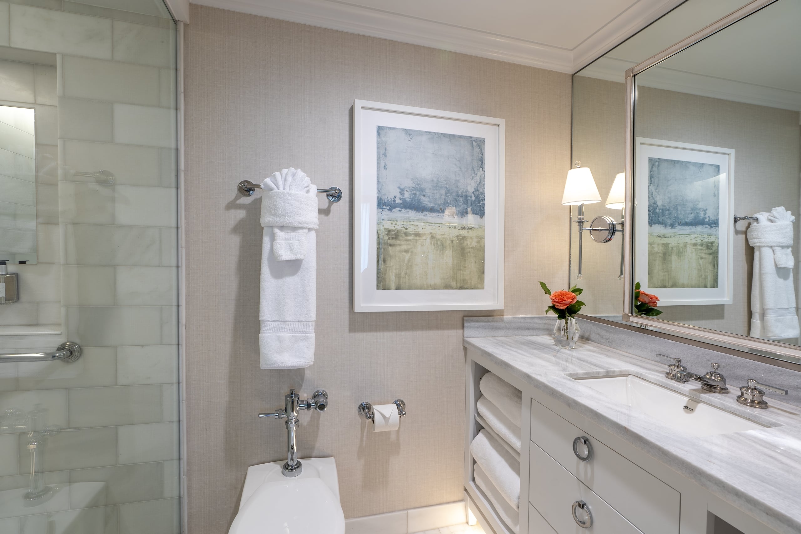 Modern hotel bathroom in New Orleans with marble vanity, fresh white towels, and elegant chrome fixtures.
