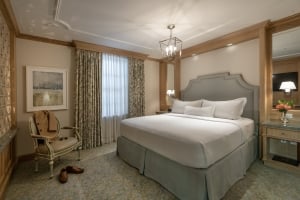 Elegant guest room at Hotel Marigny New Orleans with a king bed, classic decor, and wood paneling.