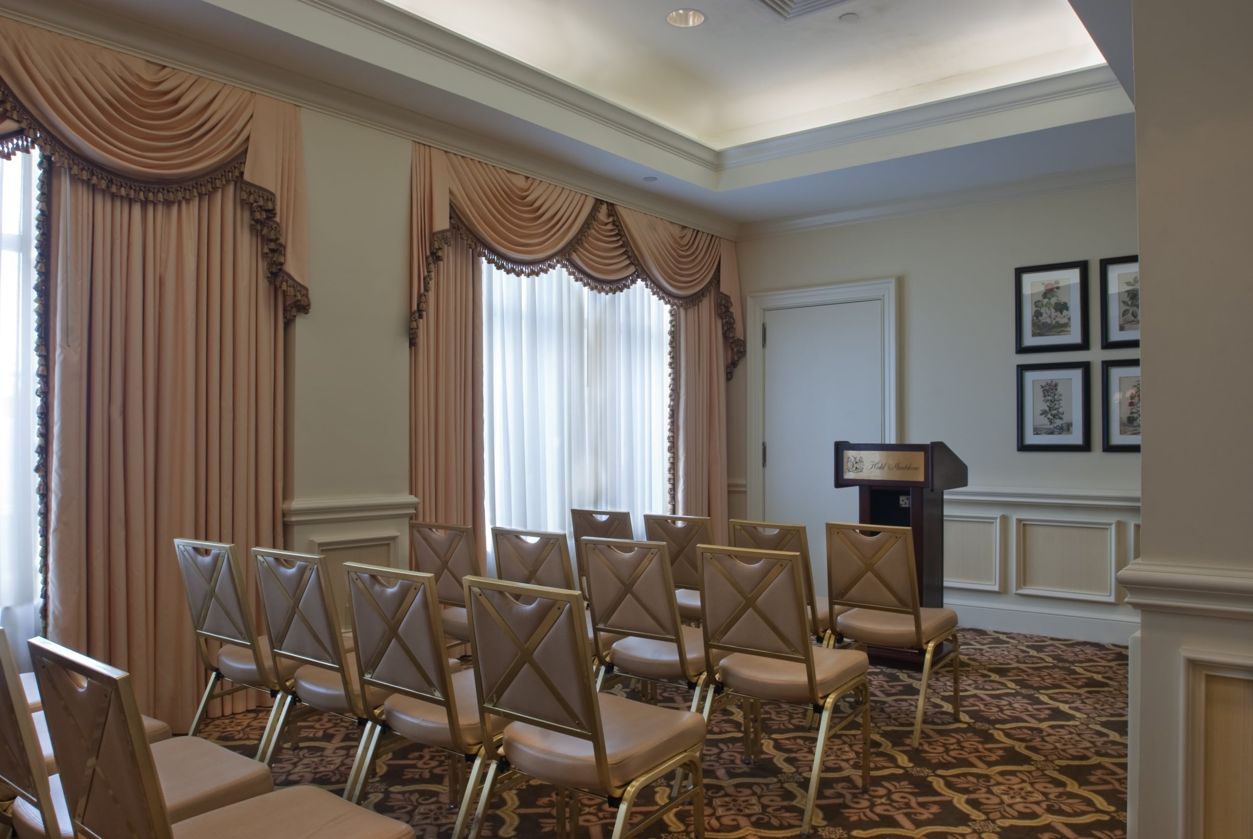 Conference room at Hotel Monteleone, New Orleans, featuring elegant drapes, chairs, and podium.
