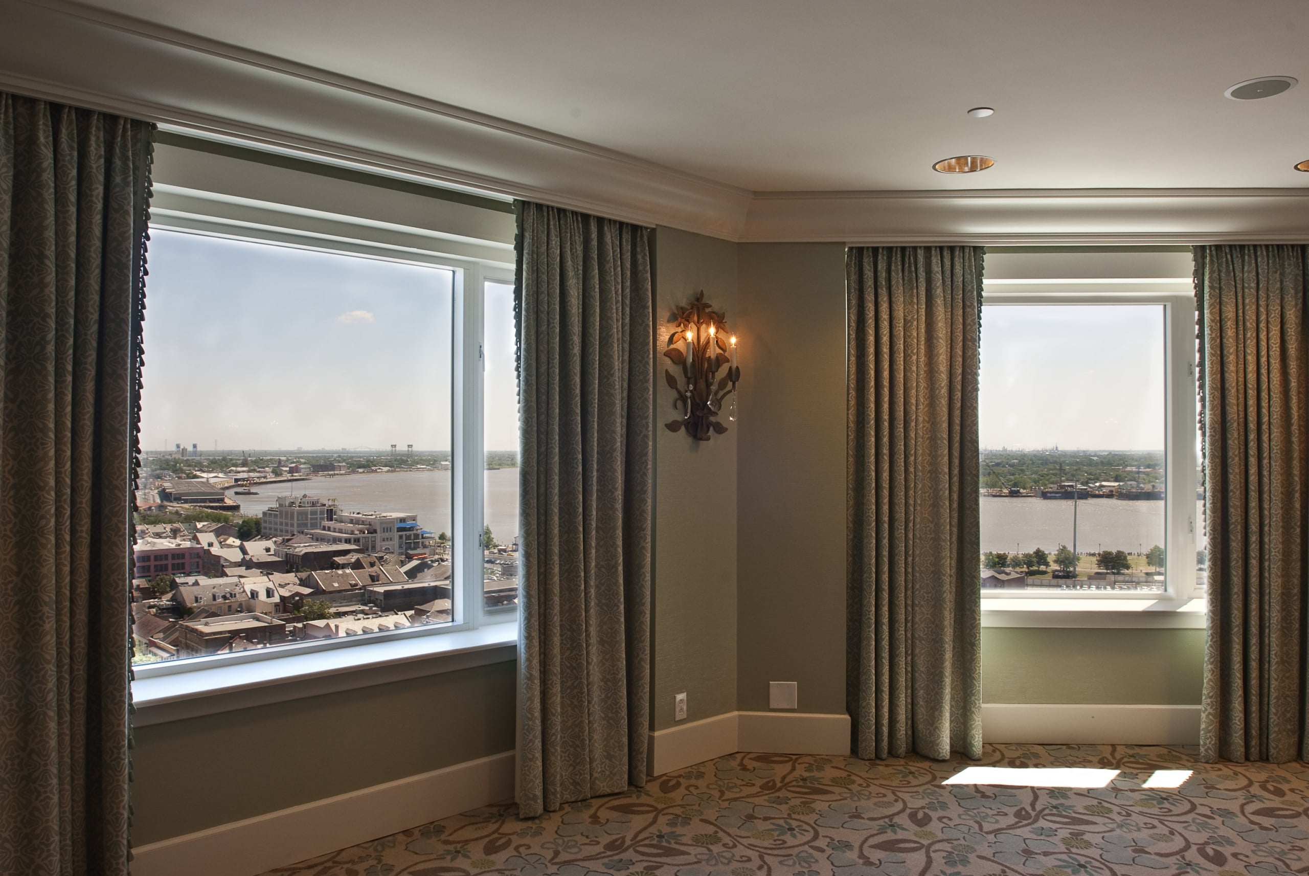 New Orleans hotel suite with panoramic river views and elegant decor.