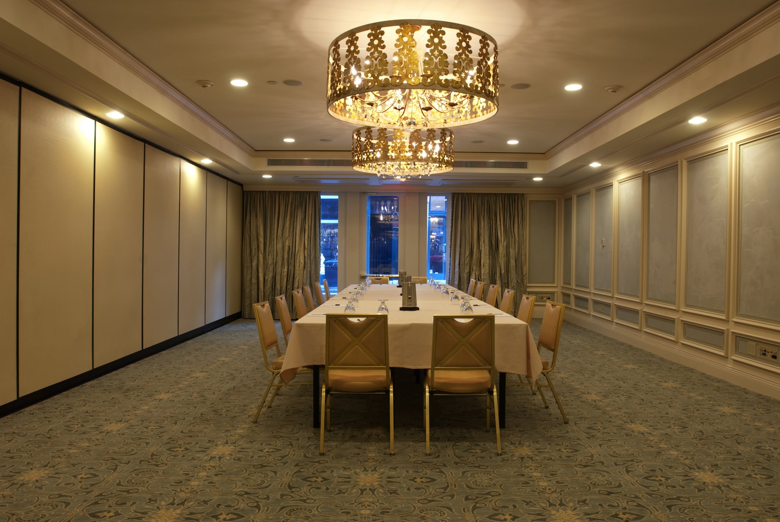 New Orleans luxury hotel meeting room with ornate chandeliers and a large table set for a conference.