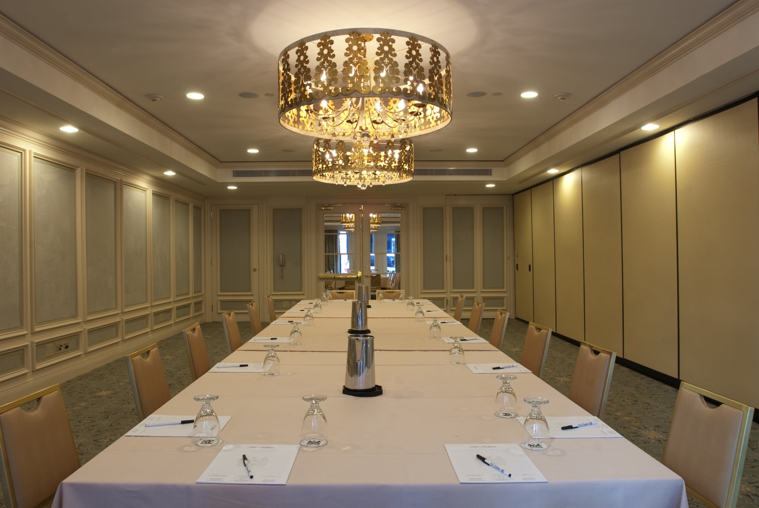 Elegant New Orleans conference room with a long meeting table, luxurious chairs, and ornate chandeliers.