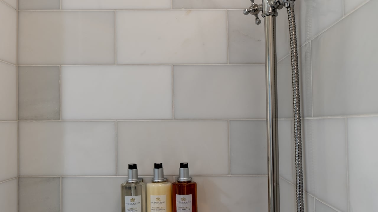 a shower with three bottles of toiletries