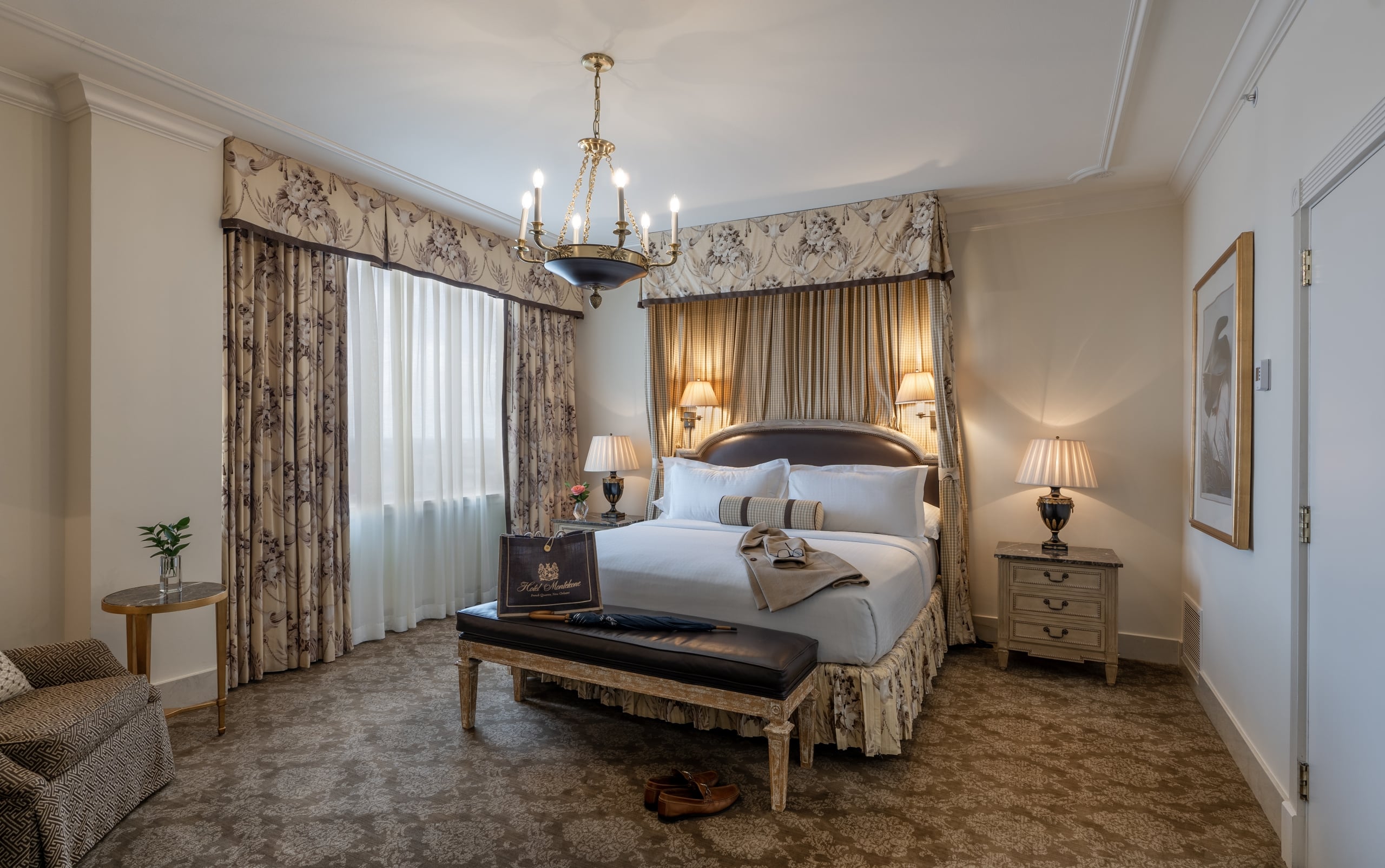 Elegant hotel bedroom at Hotel Monteleone in New Orleans with a large bed, chandelier, and patterned decor.