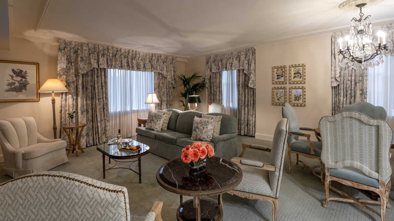 A luxurious living room with a gray sofa, armchairs, and a coffee table.