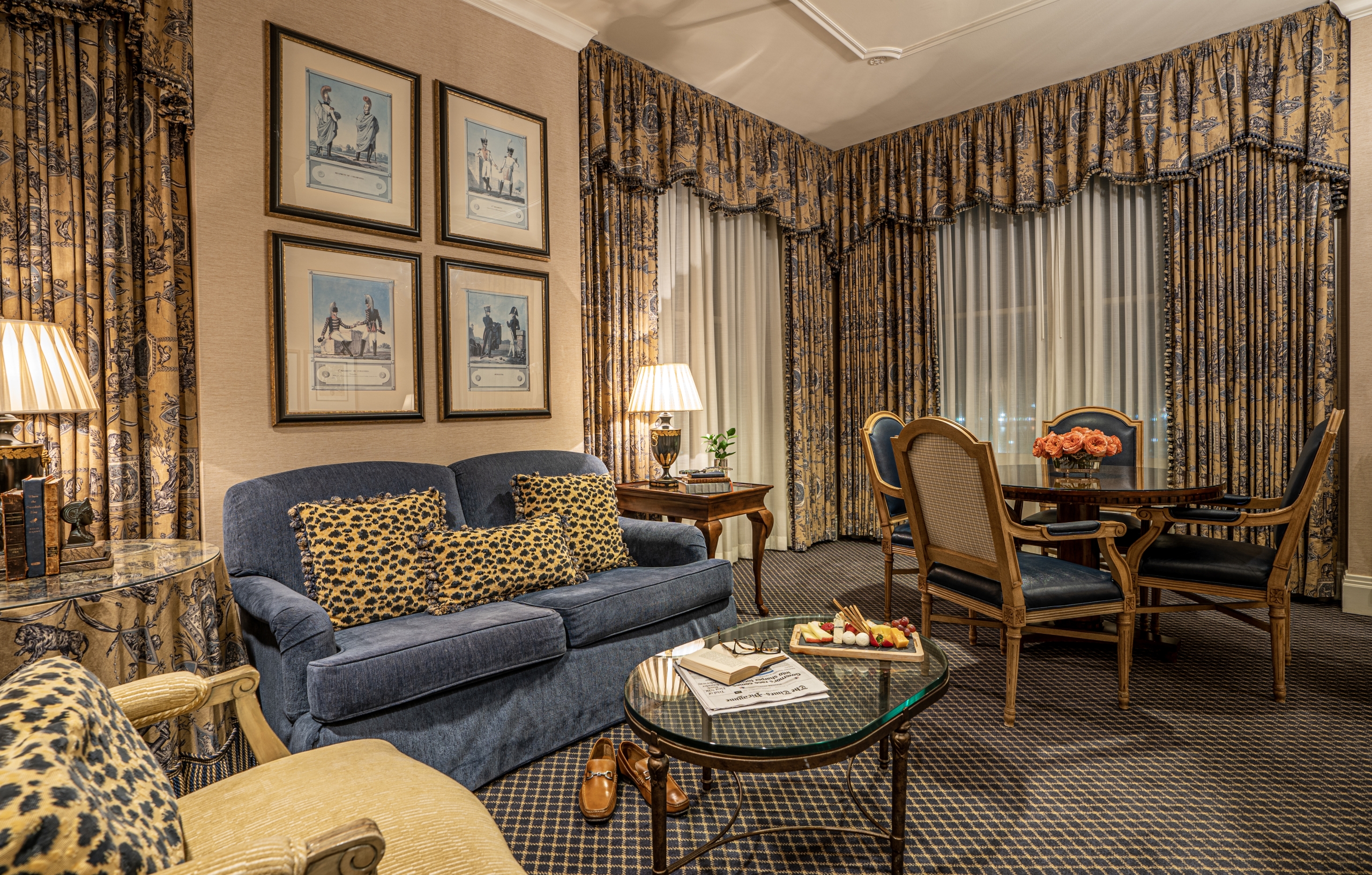 Luxurious New Orleans suite living room with classic decor, crystal chandelier, and champagne with macarons.