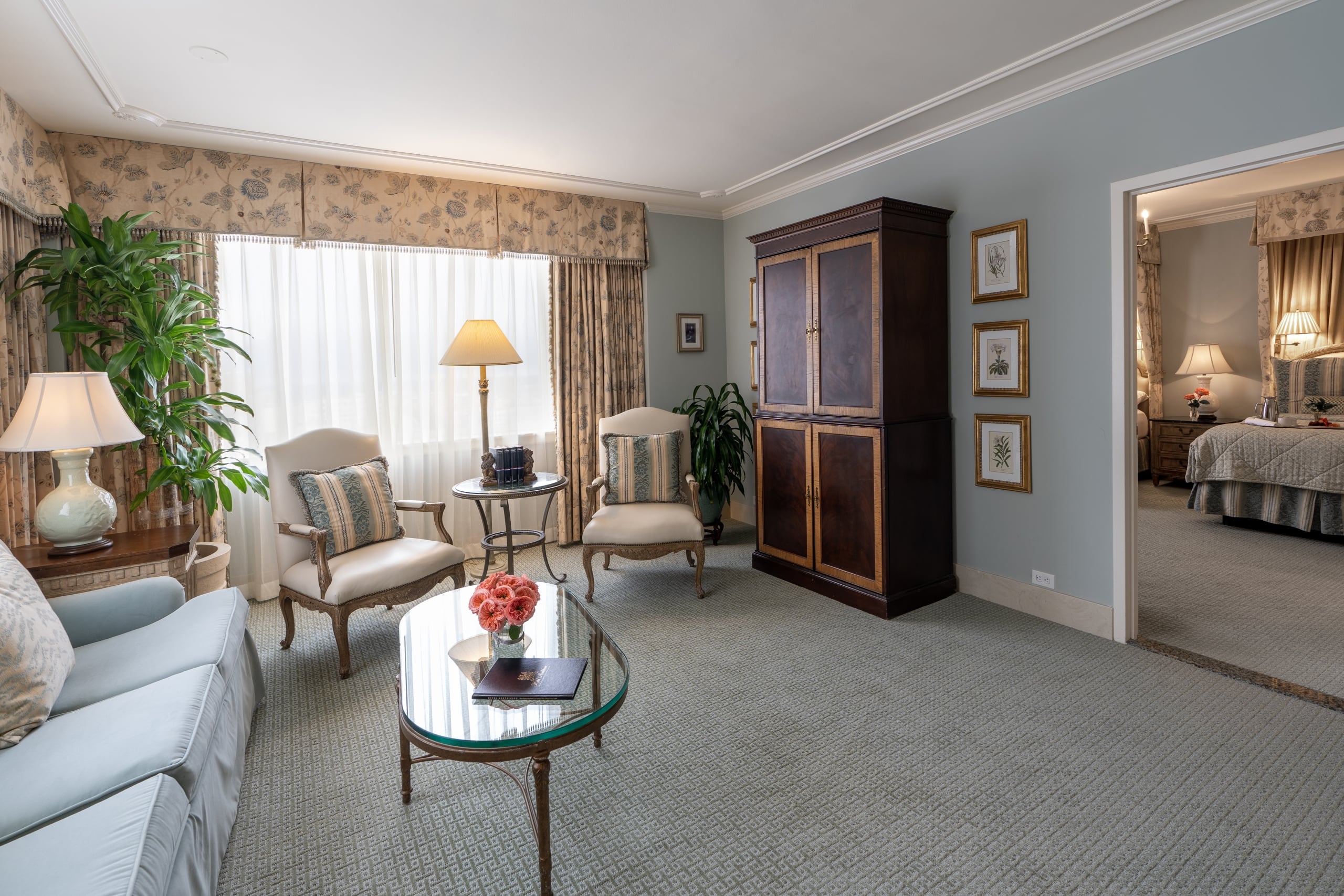 Elegant living room in a Hotel Monteleone suite, New Orleans, with comfortable seating and a bedroom view.