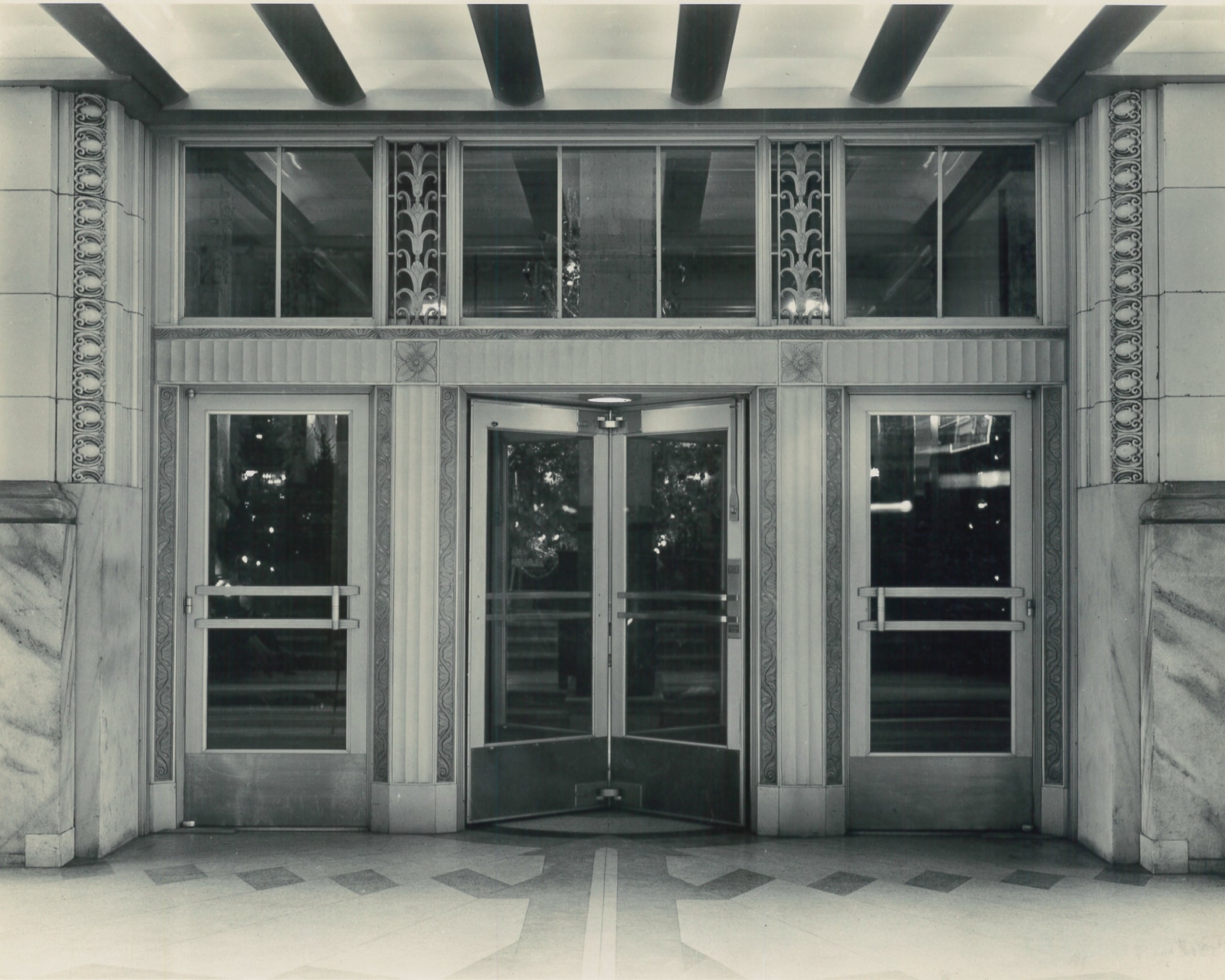 Ornate Art Deco hotel entrance in New Orleans with a revolving door, decorative windows, and marble details.